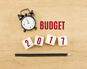 Budget 2017 year on wood cube with pencil and clock top view on wood table,New year business concept.